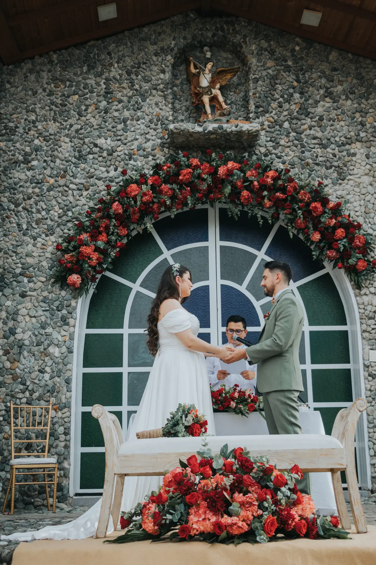 Novios en su ceremonia de boda con arco floral en Colombia